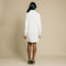 White, turtleneck, long sleeve, knit mini dress featuring feather on front side of hem.