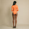 Orange, fitted, long sleeve bodysuit has cutaway detail on front. 